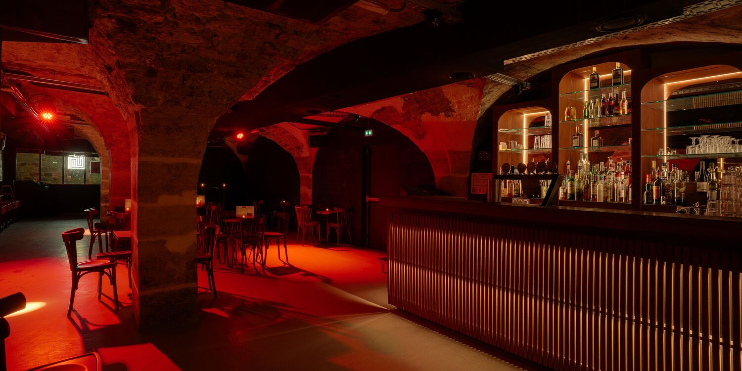 Cave voûtée avec bar lumineux au fond — espace privatisation 200 personnes Le Saumur Belleville