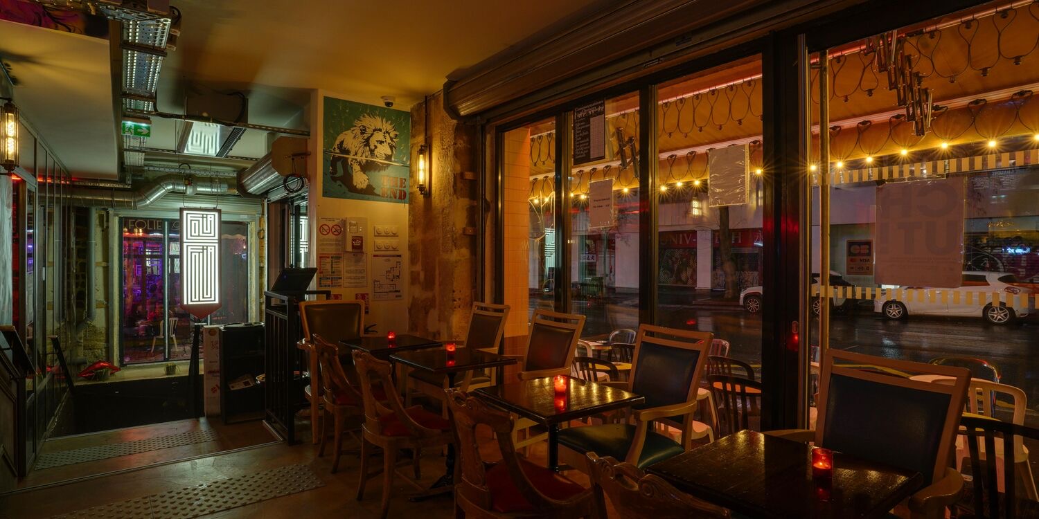 Entrée bar Le Saumur avec vue sur la rue de Belleville de nuit — tables bistrot